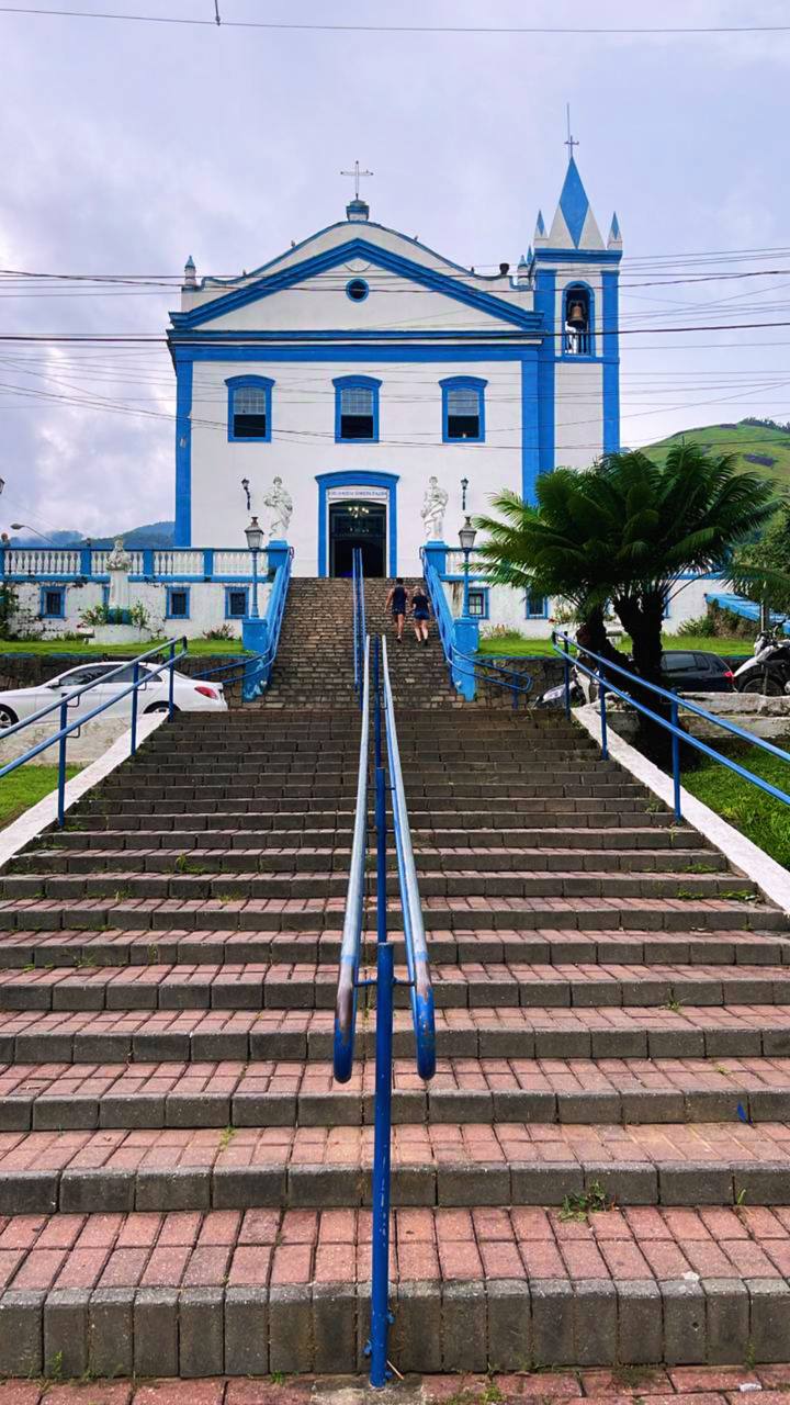Igreja colonial azul e branca com escadas e torres em Minas Gerais